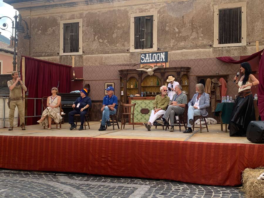 Intervista di alcune persone su un palco allestito con stile western