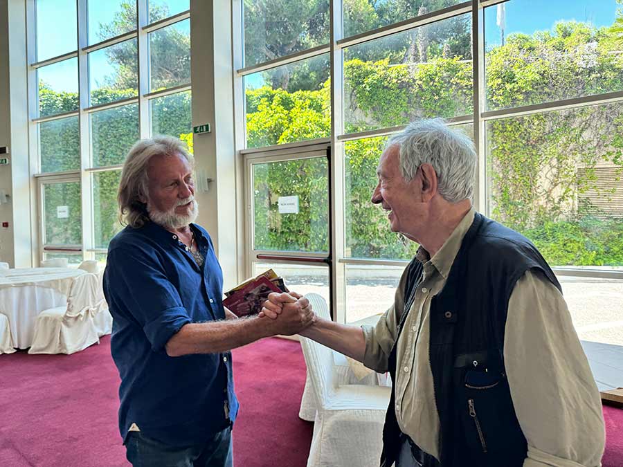 Due uomini si stringono la mano con amicizia all'interno di un ristorante